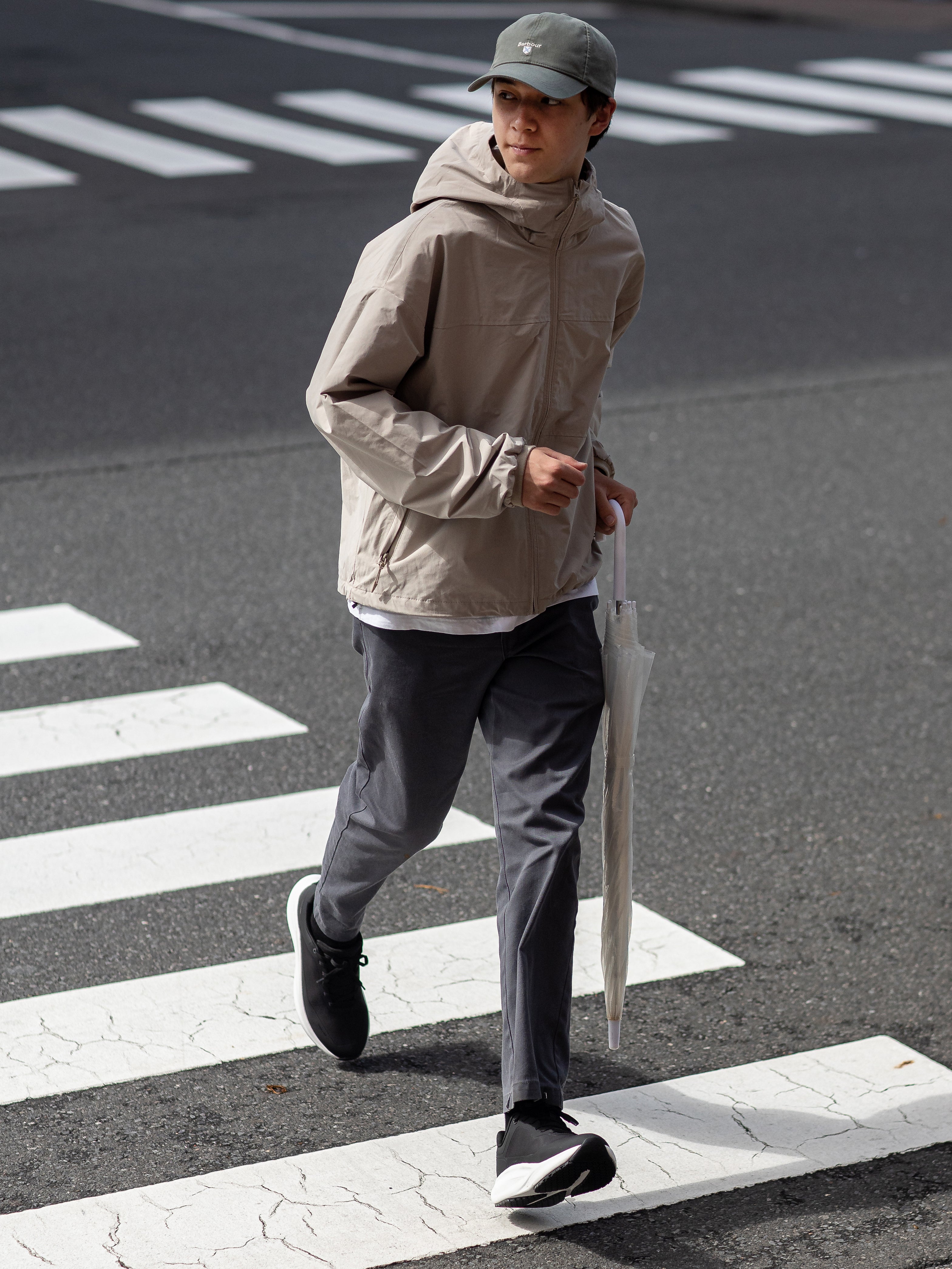 a man wearing OIVIO FIT waterproof & slip-resistant shoes crossing the road